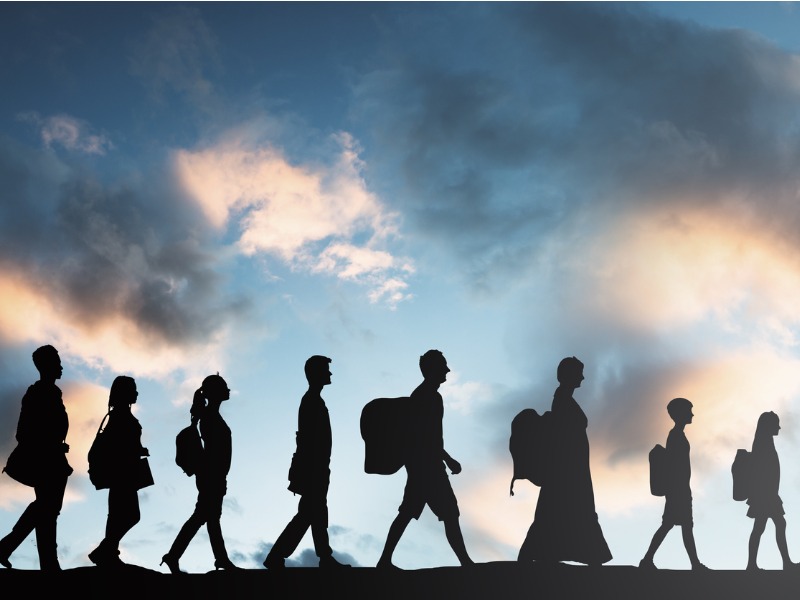 refugees-people-with-luggage-walking-in-a-row-picture-id921353784